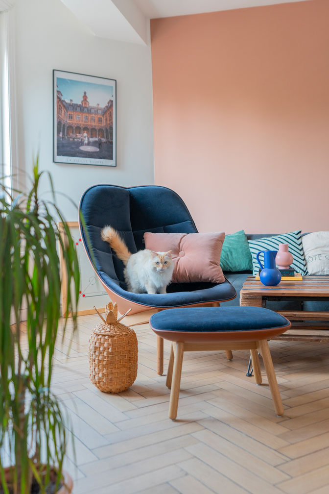 Salon lumineux et coloré avec fauteuil bleu confortable et éléments décoratifs ludiques, créant une ambiance accueillante et chaleureuse